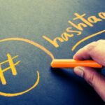 le mot hashtags écrit à la craie orange sur un tableau noir