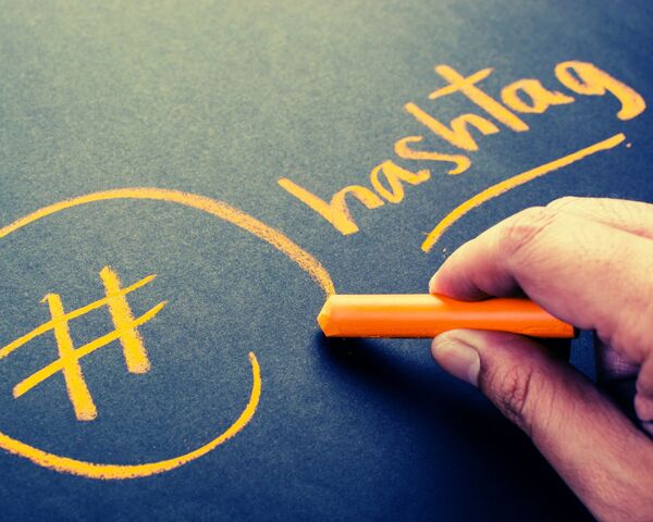 le mot hashtags écrit à la craie orange sur un tableau noir