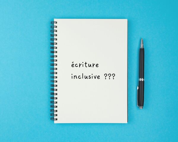 un carnet sur lequel est écrit "écriture inclusive"