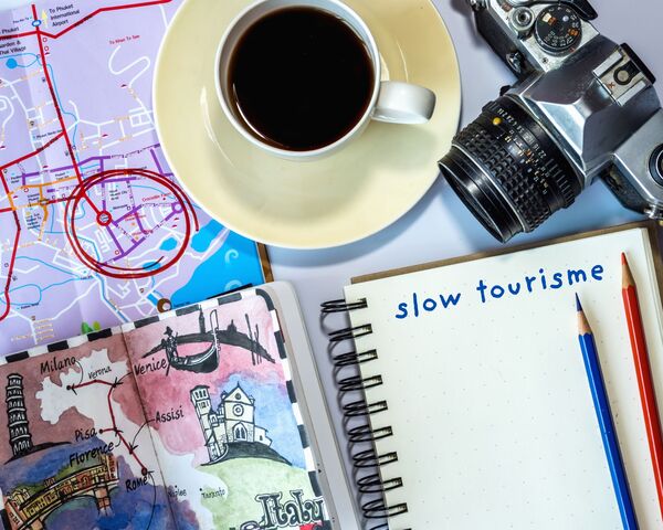 un carnet sur lequel est écrit le terme slow tourisme